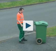 Worker following trash bin