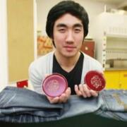 Man holding petri dishes over jeans
