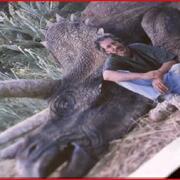 Steven Spielberg posing next to a dinosaur