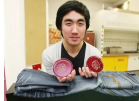 Man holding petri dishes over jeans