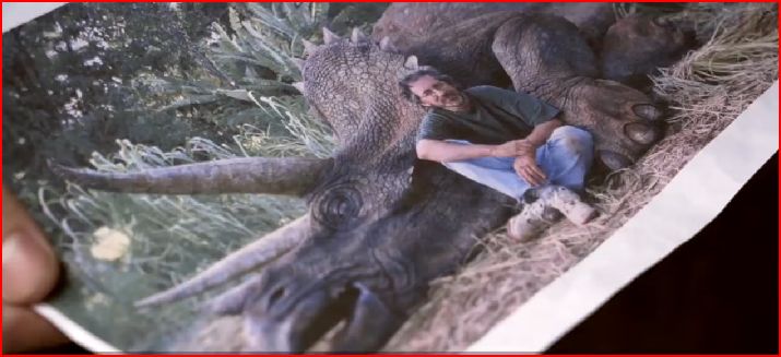 Steven Spielberg posing next to a dinosaur