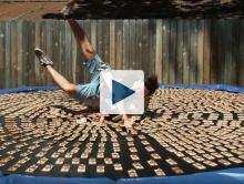 Dan jumping onto a trampoline covered in mousetraps