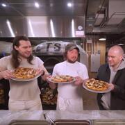 Three men holding pizzas