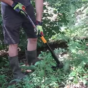 Man pulling weed with tool
